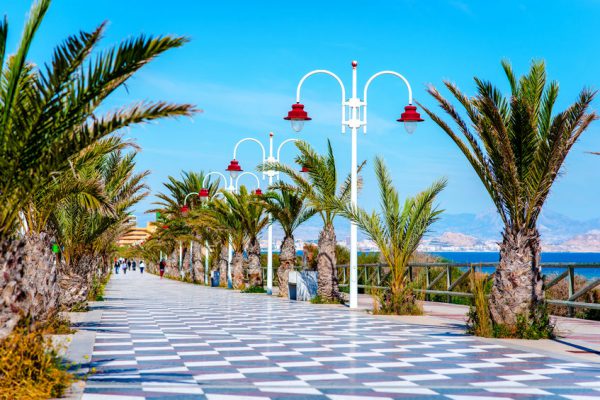 53145072 - people walking along the seafront palm-lined promenade in los arenales del sol. costa blanca, spain